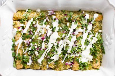 Finished Enchiladas Verdes Recipe Garnished with cheese, red onion, and fresh cilantro