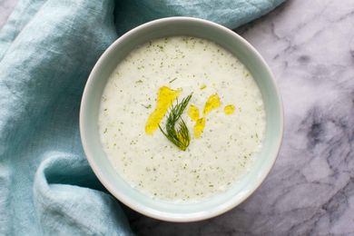 Cold Cucumber Soup in a pale blue bowl garnished with dill and olive oil