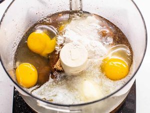Eggs, sugar, and flour in a food processor for a baking recipe