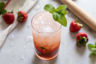 Summer Mojito Cocktail - strawberries on table with mint in glass
