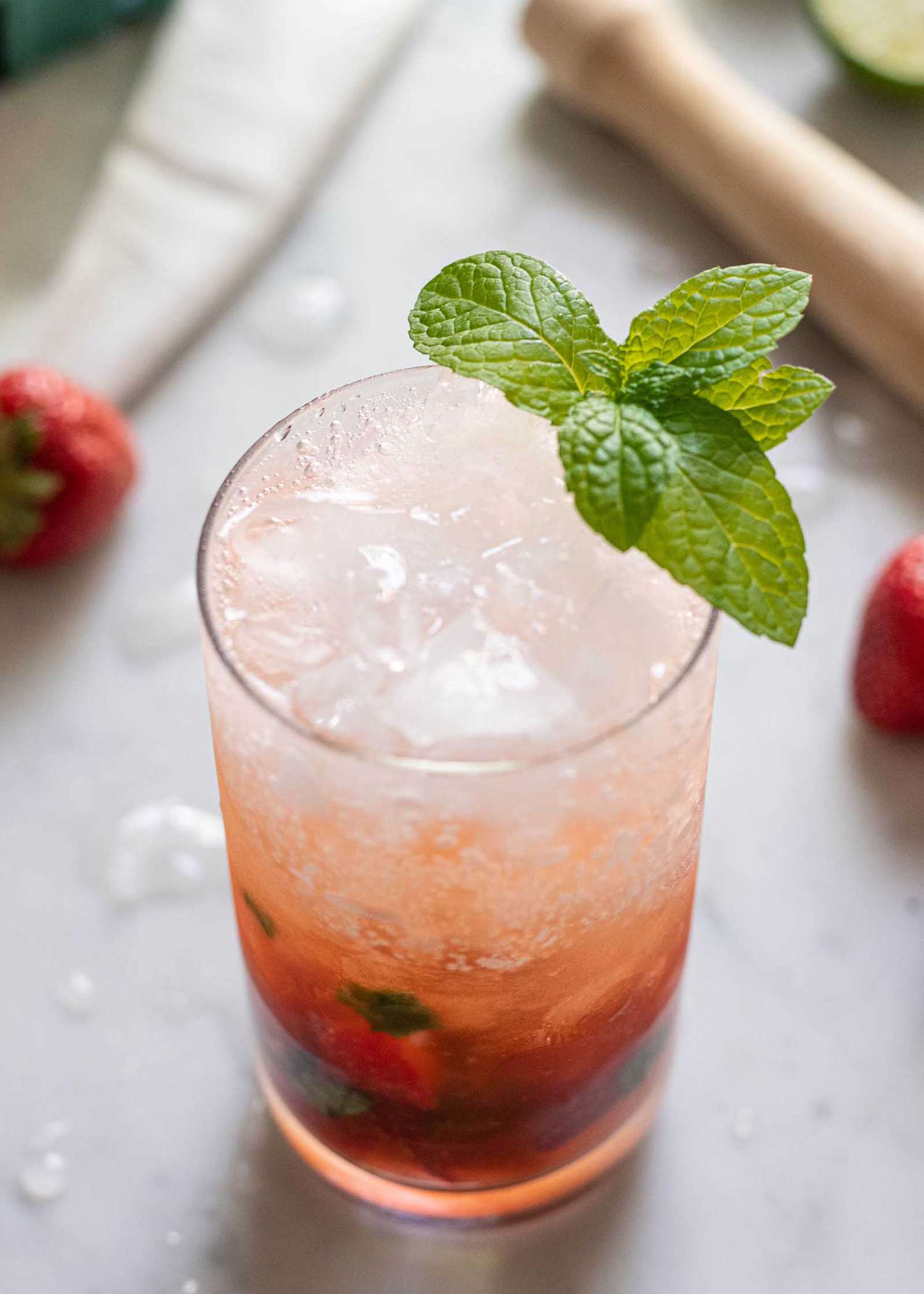 How to Make a Mojito Cocktail red cocktail in glass with strawberries and mint