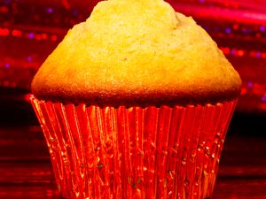 Mantecadas in Red Shiny Cupcake Liner, Surrounded by a Sparkly Red Background