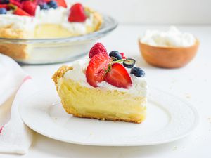 A slice of buttermilk pie set in front of the whole pie.