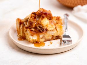 Slice of Apple Bread Pudding on a Plate with Sauce Drizzling