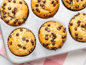 Banana Chocolate Chip Muffins in a Baking Tray Over a Kitchen Towel