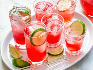 Highball glasses of raspberry lime rickey set on a tray