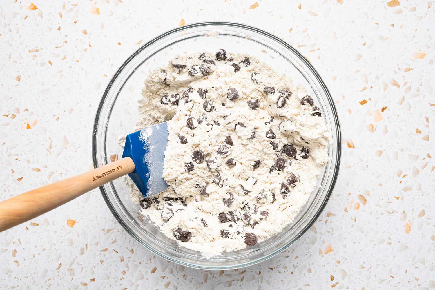 Chocolate Chips Folded Into the Bowl of Dry Ingredients Using a Spatula 