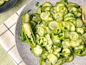 Spicy Cucumber and Jalapeno Salad on a Plate with a Halved Jalapeno and Utensils 