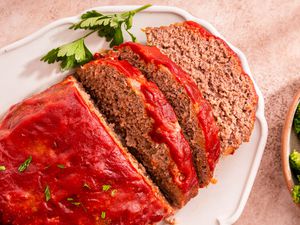 Easy Meatloaf With Some of It Cut Into Slices, All on a Platter, and Next to It, a Bowl of Broccoli