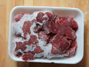 a frozen package of beef stew meat with freezer burn