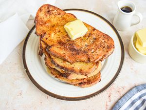 Easy French Toast on a Plate with Butter, Surrounded by a Small Bowl with More Butter and Small Pitcher with Maple Syrup