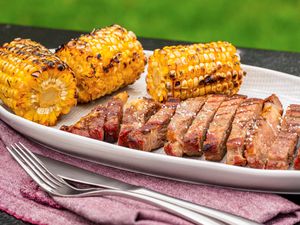 Grilled steak and corn on a platter