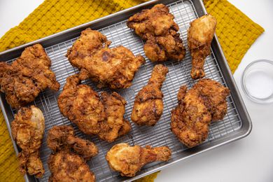 Fried Chicken on a Wire Rack over a Baking Tray on a Kitchen Towel for How to Deep Fry