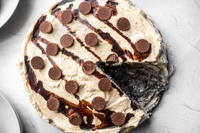 Chocolate Peanut Butter Icebox Cake Wrapped in Plastic Wrap in a Springform Pan with a Slice Cut Out