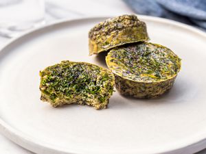 Kale and Portobello Egg Bites on a Plate with One Bitten 