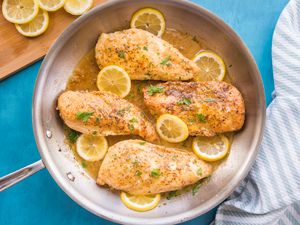 Lemon Pepper Chicken in a Pan Garnished with Shredded Parsley and Lemon Slices