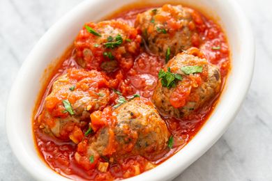 Turkey Meatballs in Tomato Sauce and Topped With Basil in a White Dish