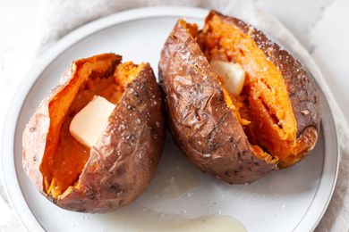 Plate with Microwave Sweet Potatoes Split in Half and Topped with a Slab of Butter and Salt 