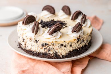Oreo cheesecake decorated with whipped cream and Oreos on a plate
