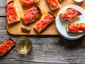 Pan con Tomate on a Wooden Cutting Board and Small Plate Next to a Glass