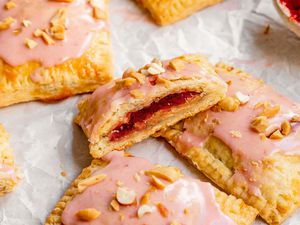 A Peanut Butter and Jelly Pop Tart Cut in Half, Leaning on More Gourmet Pop Tarts on a Piece of Parchment Paper