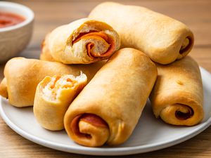 Pepperoni Rolls on a Plate with Bowl of Marinara in Background