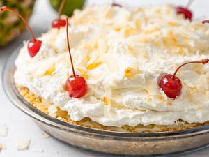 Piña Colada Pie Topped with Toasted Coconut Flakes and Maraschino Cherries