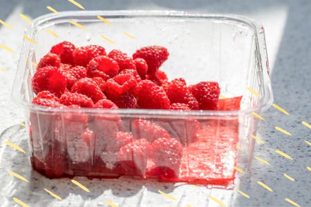 Yellow Doodles Overlay a Plastic Container With Fresh Raspberries