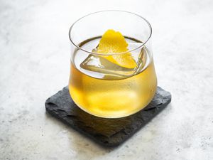 Rusty Nail on a Granite Coaster Garnished with Lemon Peel