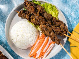 Plate With Sach Ko Jakak (Cambodian Grilled Lemongrass Beef Skewers) With a Mound of Rice and Sliced Daikon Radish and Carrot Pickle