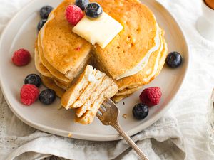Stack of Sourdough Pancakes with Berries and Butter with a Bite Size on a Fork