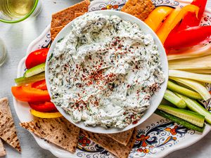 Bowl of Easy Spinach Dip Surrounded by Veggie Strips and Pita Triangles