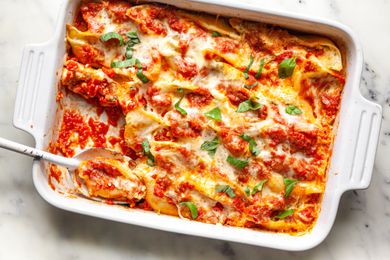 Stuffed Shells in a Casserole Dish with Some on a Serving Spoon