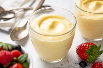 Vanilla Custard in Pudding Jars Surrounded by Spoons and Berries