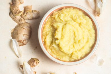 Ginger Garlic Paste in a Bowl Surrounded by Pieces of Garlic and Ginger