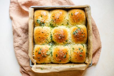 Overhead view of garlic Parmesan pull apart bread in a pan with a linen underneath.