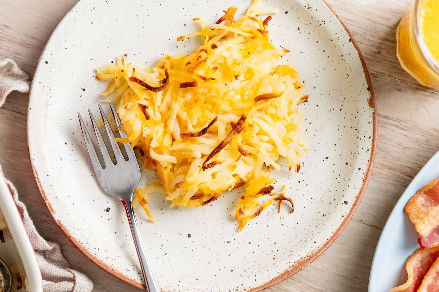 Overhead shot of copycat Cracker Barrel hash brown casserole on a plate with a fork